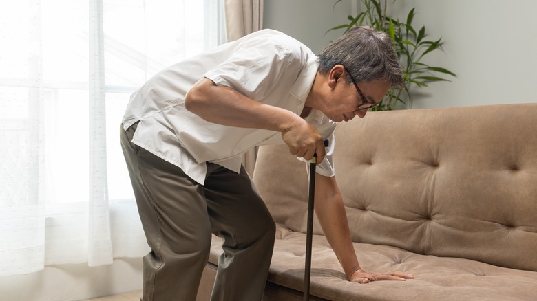 Older adult standing up with cane