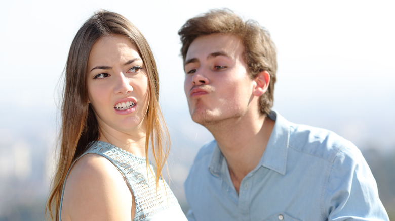 A woman rejects a man's attempt to kiss her