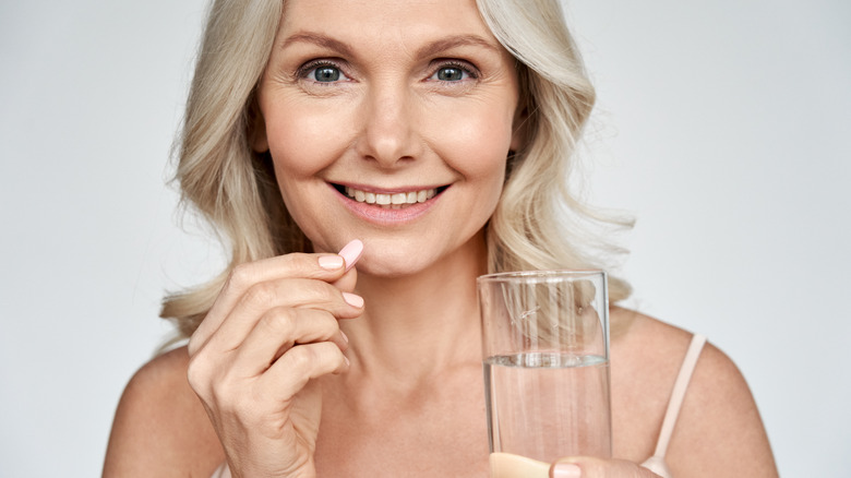 Woman taking medication with water