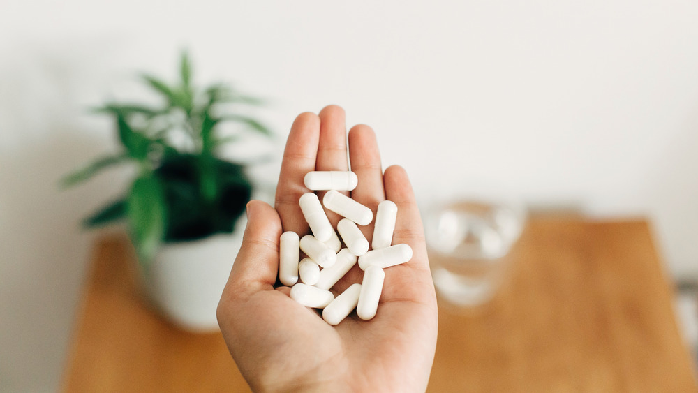 Hand holding magnesium supplement pills