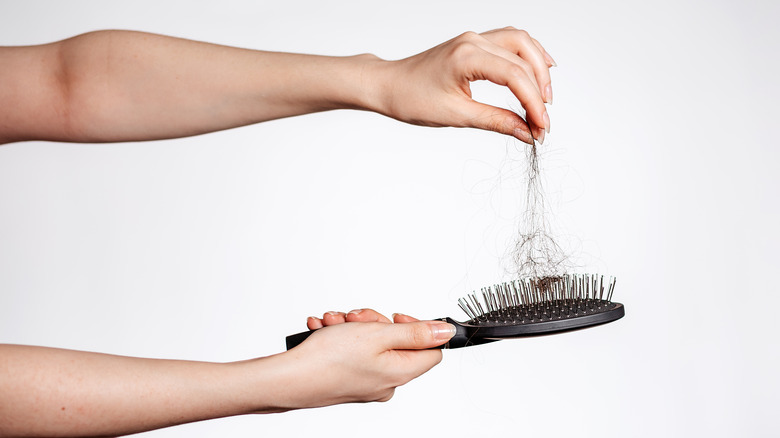 Woman cleaning hair out of a hair brush