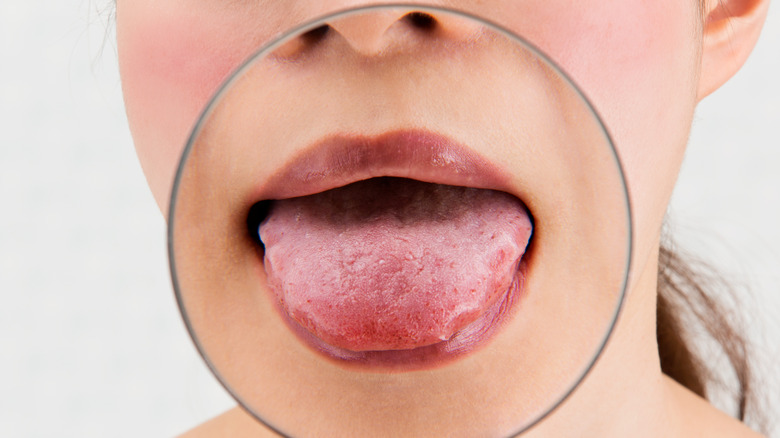 Close up of magnifying glass on woman's tongue