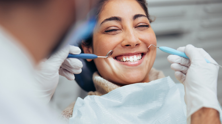 Woman in dentist chair having teeth examined