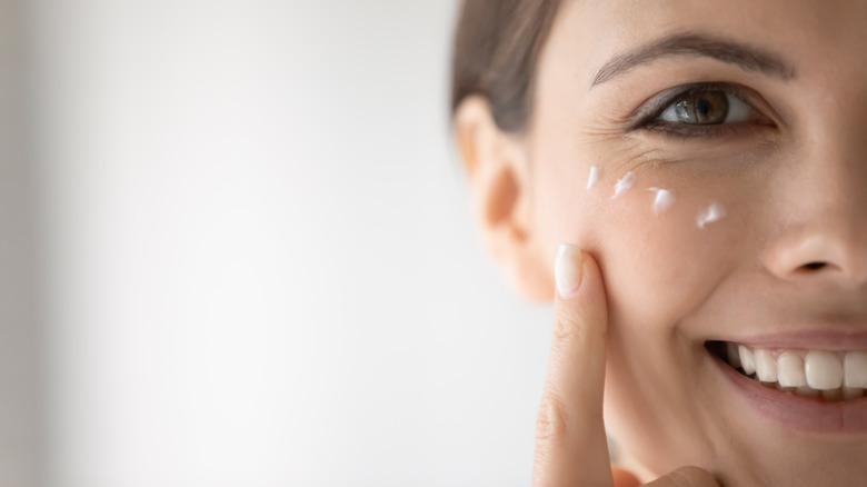 White woman applying eye cream