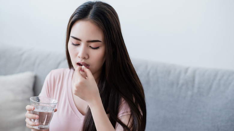 A woman taking a pill