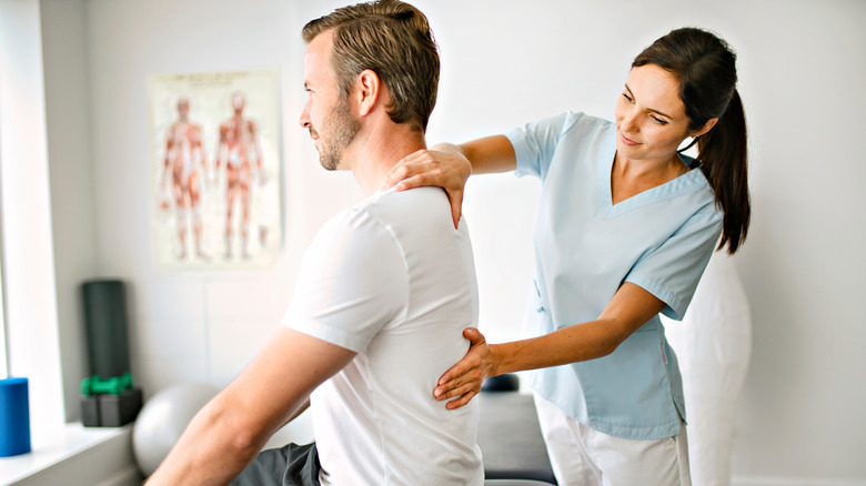 Chiropractor examining man's back