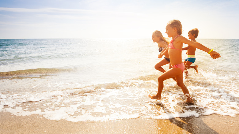 Children are running into the ocean