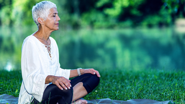 Older woman meditating outside