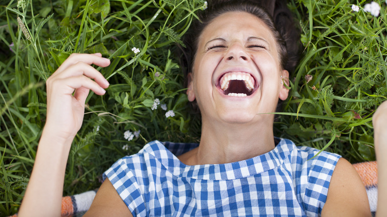 Woman lying in grass laughing