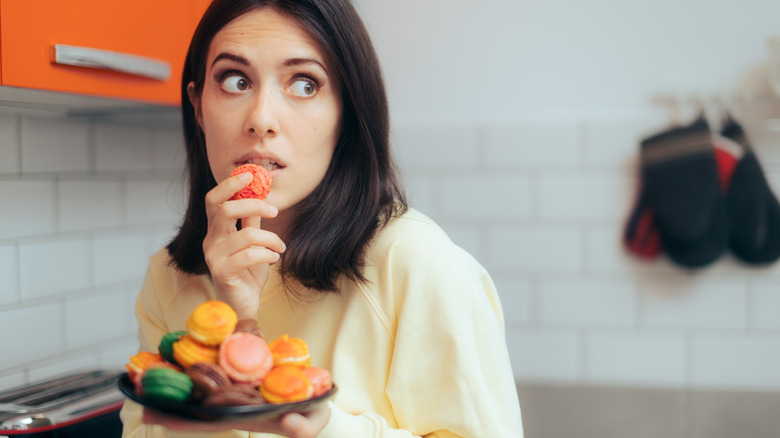 woman eating a plateful of macaroons