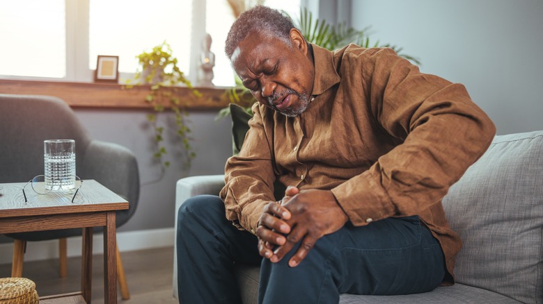 Older man holding knee in pain