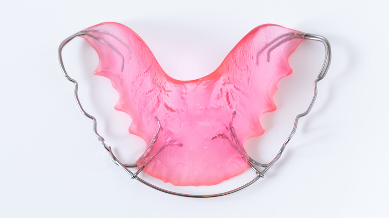 Pink dental retainer on white background