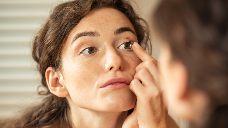 Woman putting in contact lens