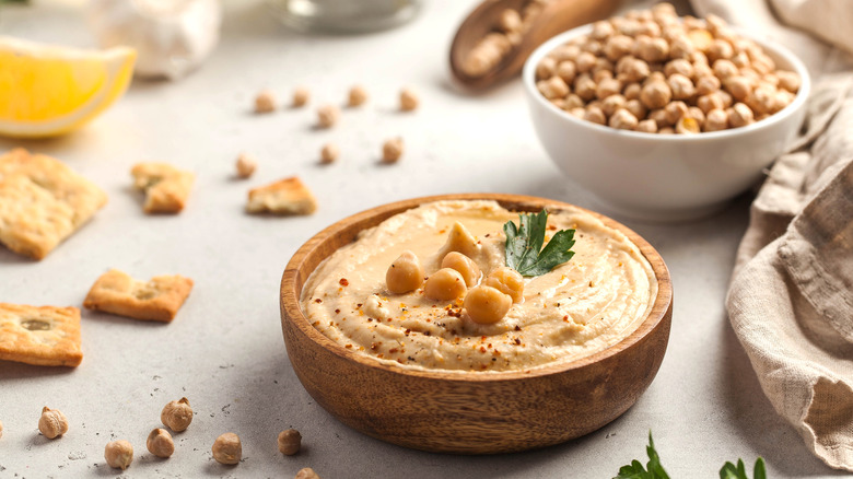 A bowl of hummus next to a bowl of chickpeas