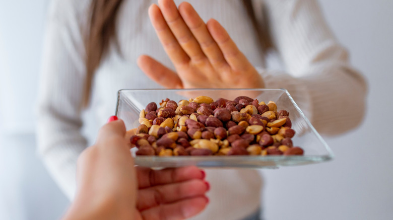 Woman refusing to eat peanuts