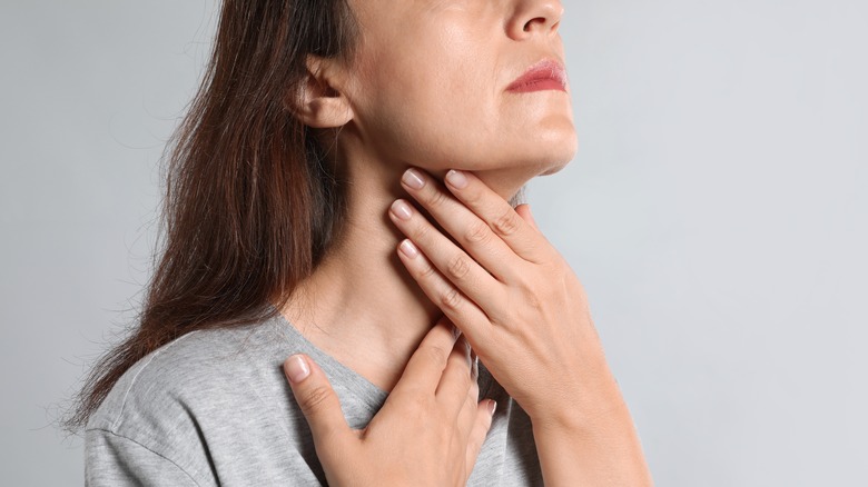 Woman checking her thyroid gland