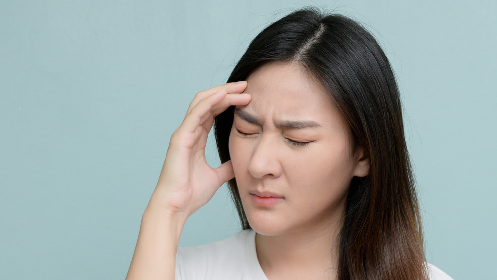 woman with a headache, touching forehead