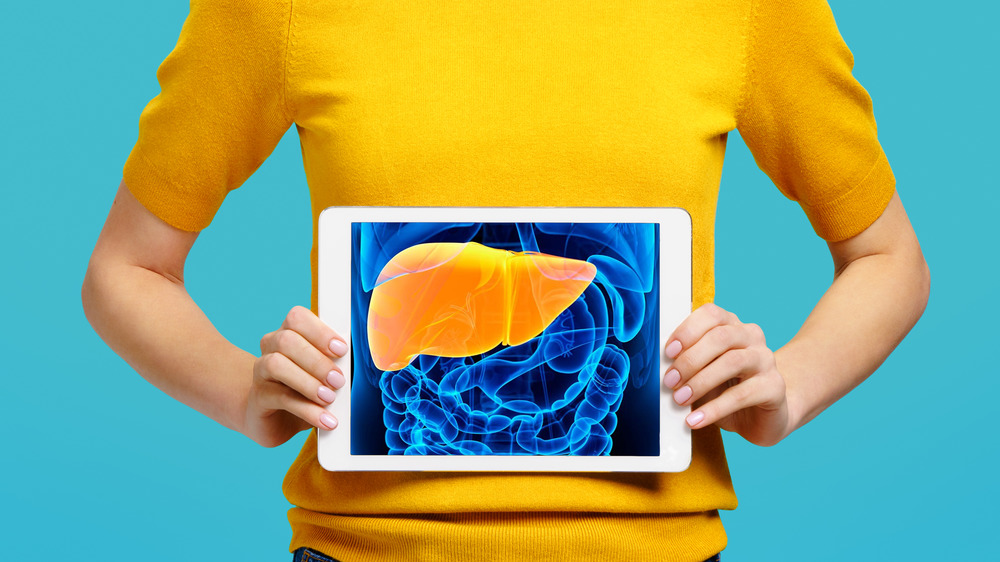 woman holding digital image of liver