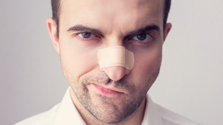 Man with bandage over his nose