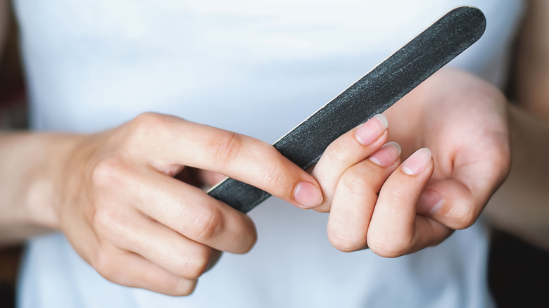 Close up as a woman files her nails