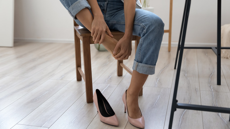 woman rubbing sore foot