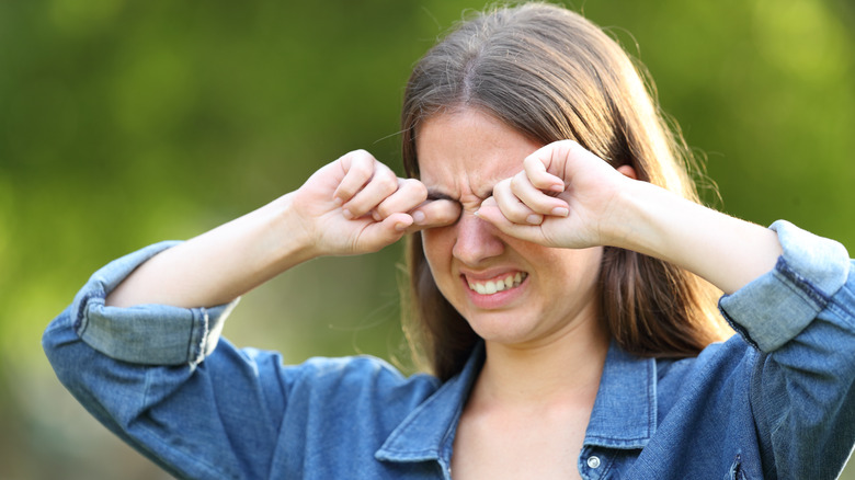 A woman rubbing her eyes