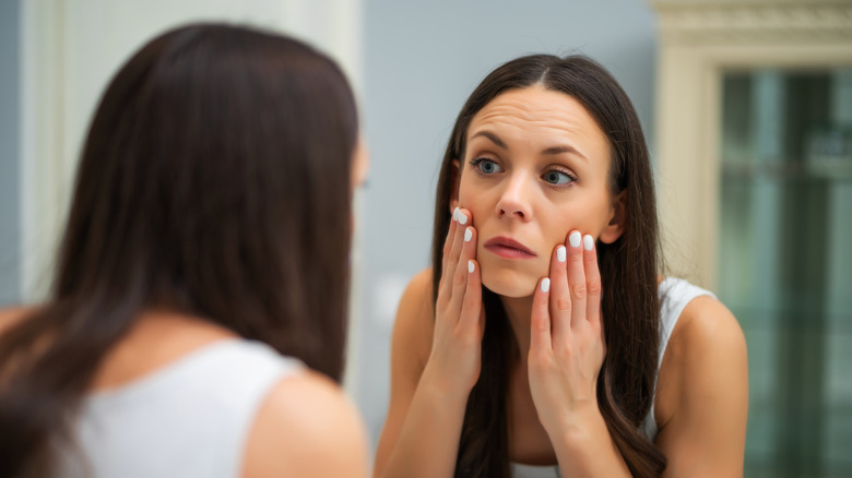 Woman checking her eyes in the mirror