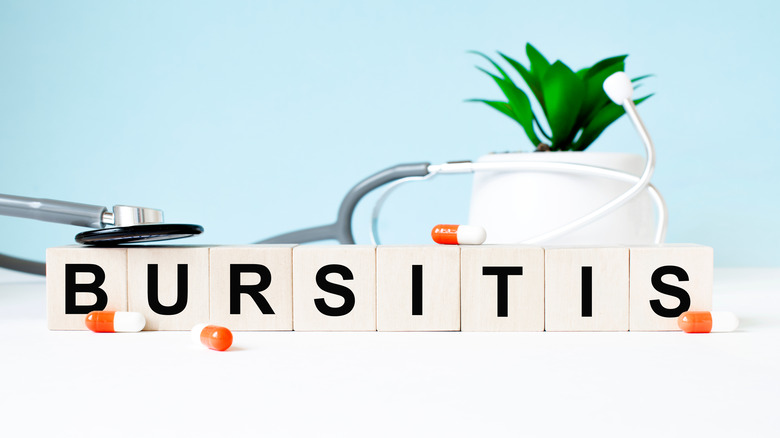 The word BURSITIS is written on wooden cubes near a stethoscope on a wooden background