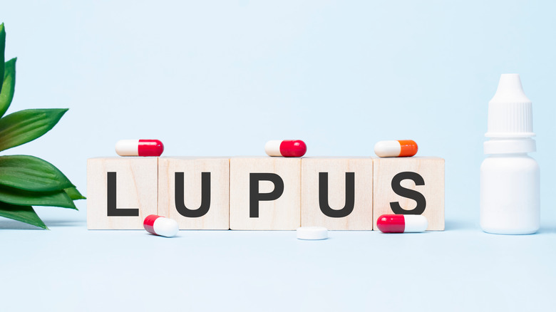 LUPUS word made with building blocks. A row of wooden cubes with a word written in black font is located on white background.