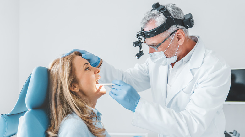 doctor examining a woman's tonsils