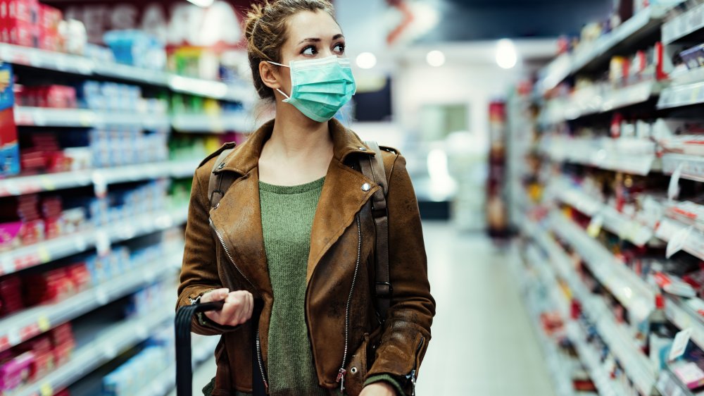 Woman shops wearing a mask