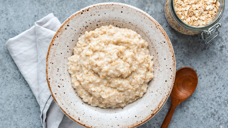 A bowl of bland oatmeal with a cup of tea