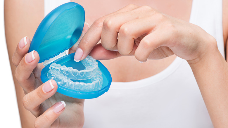 Woman's hands holding mouthguard and case
