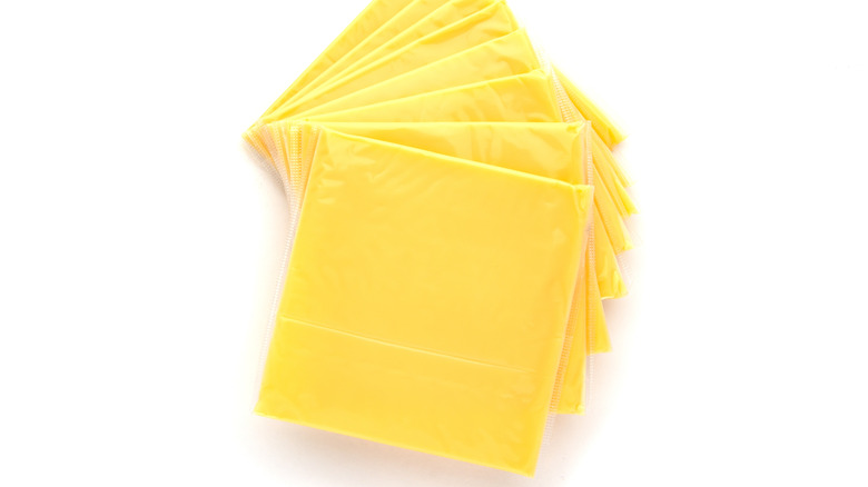 Indivdually wrapped processed cheese with an all white background 