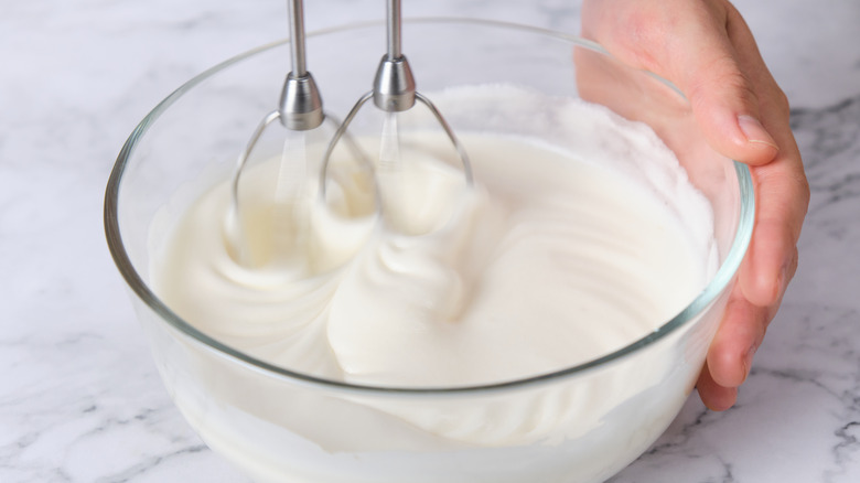 white cake batter being mixed with an automatic mixer 