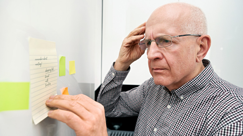 older man looking confused by a white board