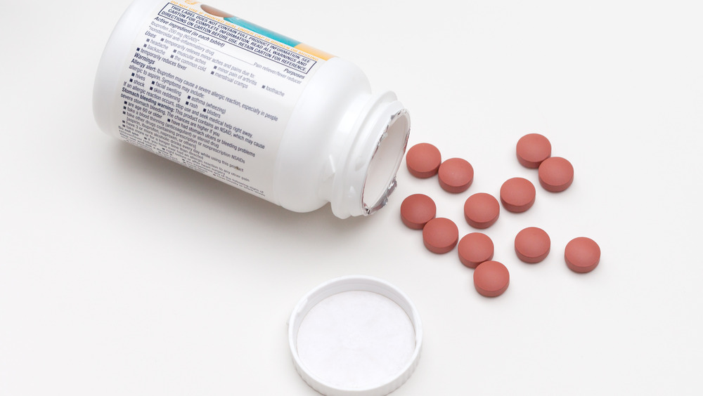 ibuprofen tablets on table next to bottle