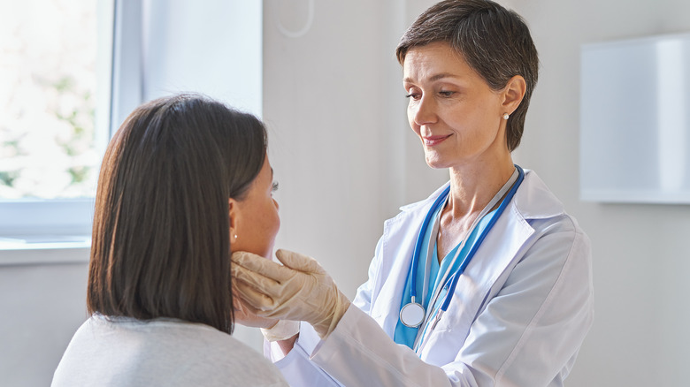 Female doctor checking young woman