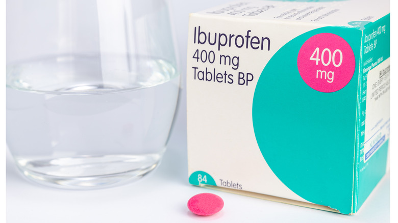 Ibuprofen tablet with box and glass of water