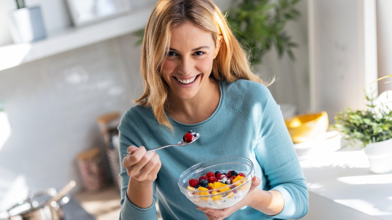 woman eating a bowl of berries