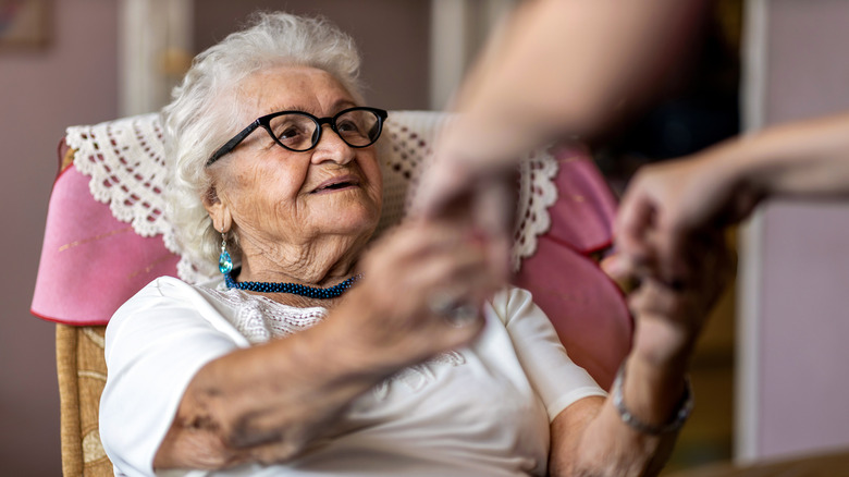 Elderly woman smiling at another person that is off-screen