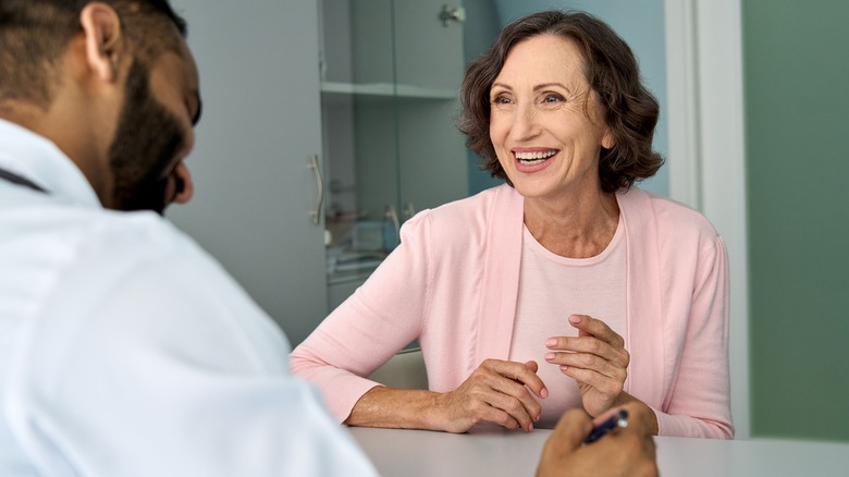 Older woman smiling speaking to doctor