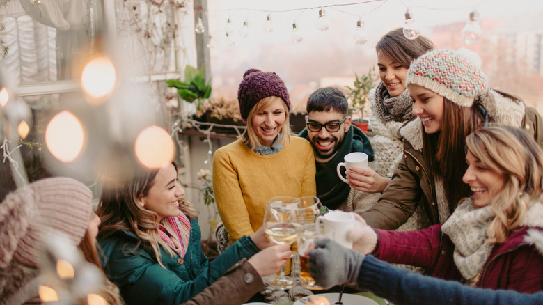 friends drinking wine on winter terrace