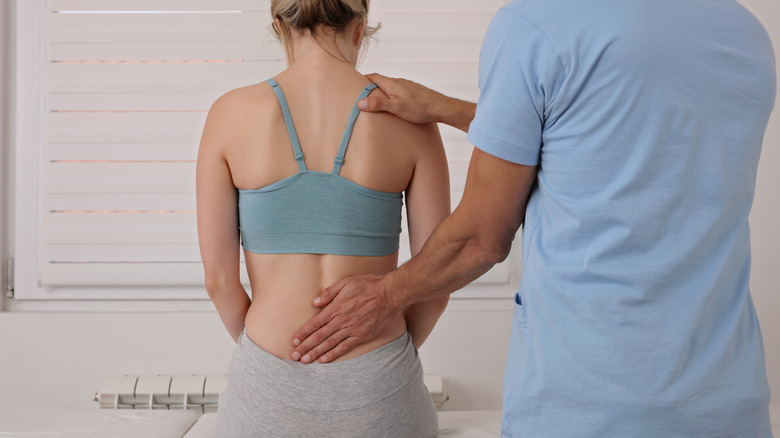 Doctor examines a woman's lower back