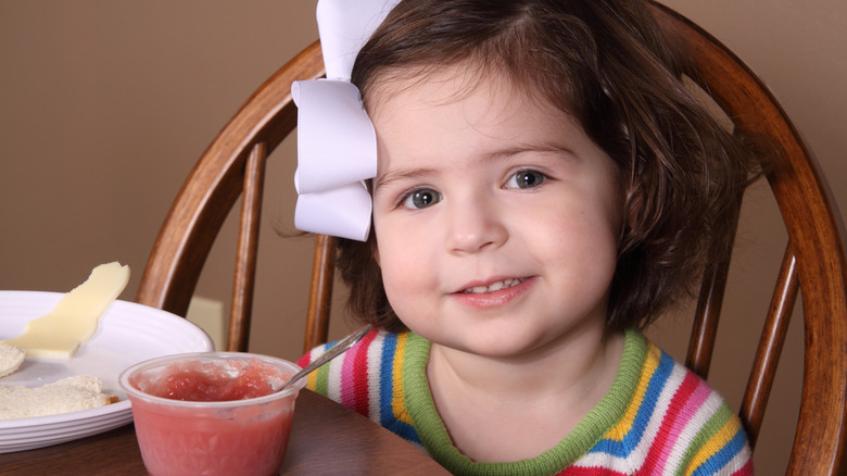 Smiling girl sitting at kitchen table 