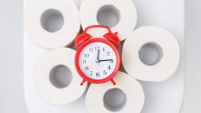 Alarm clock on rolls of toilet paper