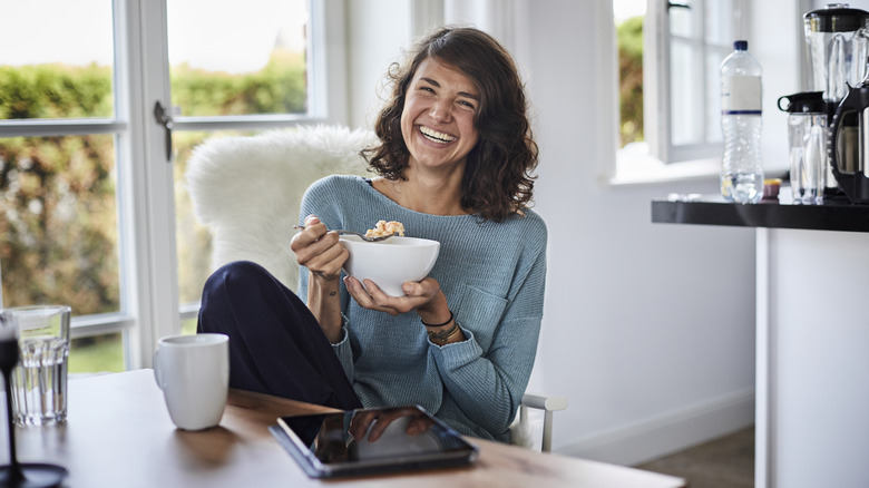 smiling girl eating cereal from a bowl