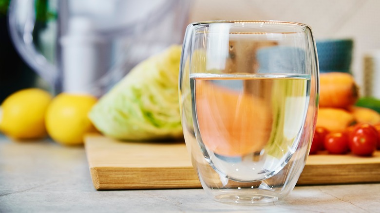 tomatoes and produce behind water glass