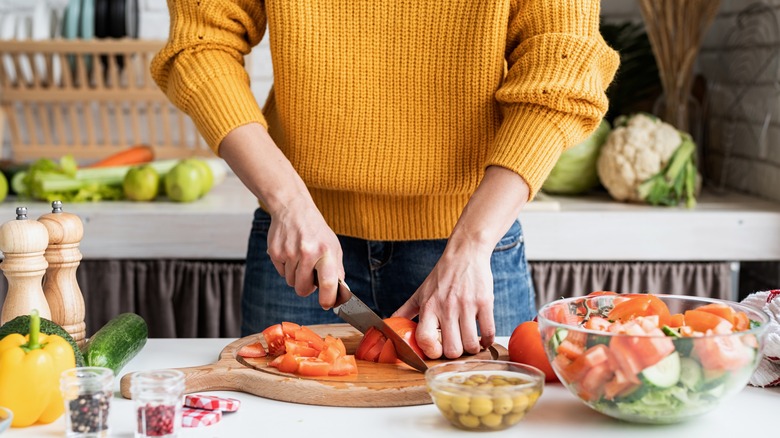 woman slicing tomatoes in kitchen