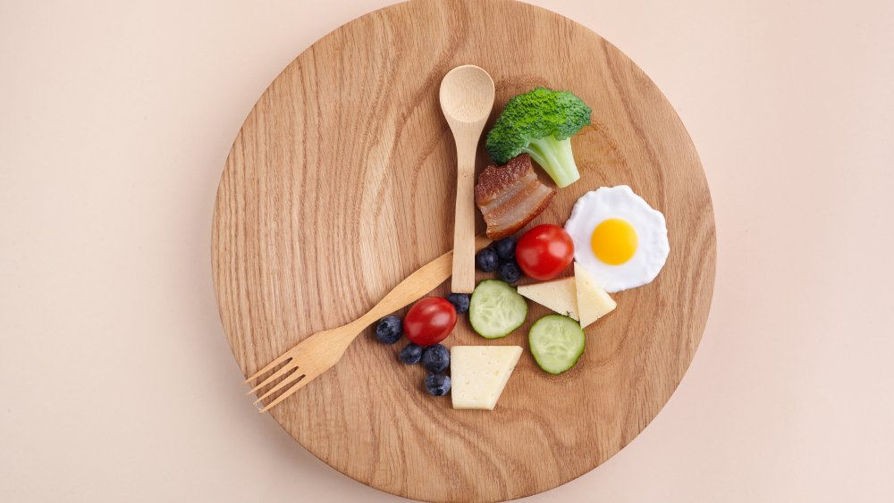 Breakfast on a plate with utensils that look like a clock.